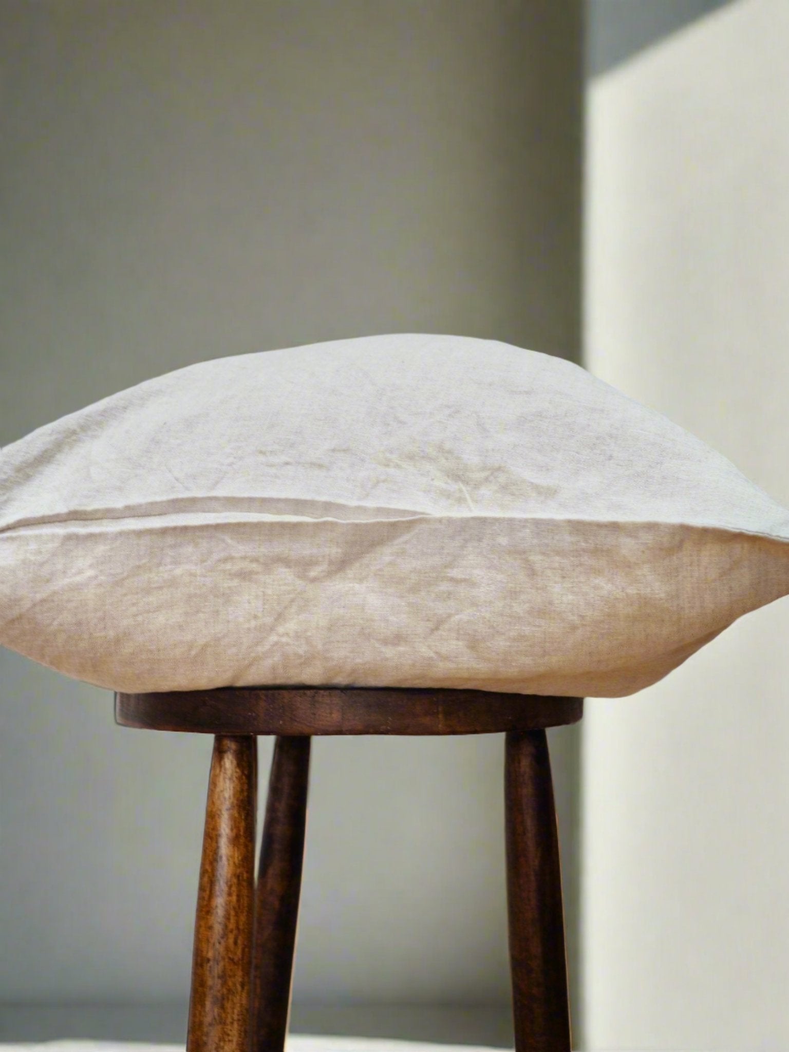 Linen Cushion Cover in Oatmeal - TSL | soft linen cushion cover on a stool in a sunlit room 