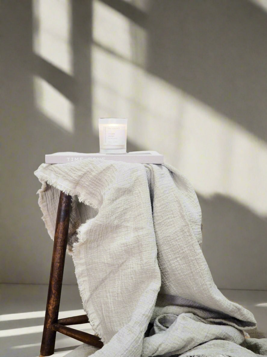 Linen Throw Blanket in Natural Oatmeal - TSL, draped over a stool 